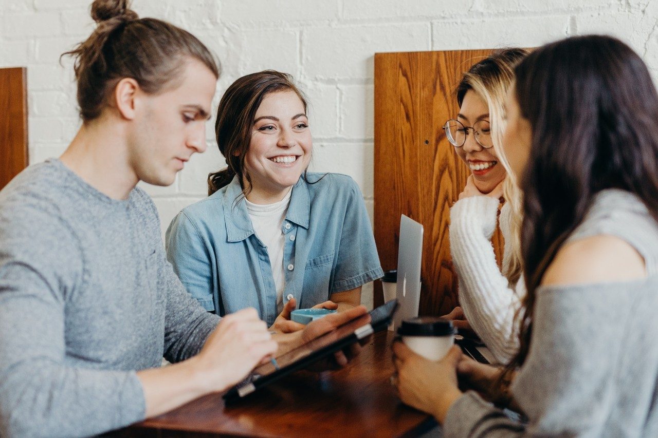 Four people sitting at table in coffee shop