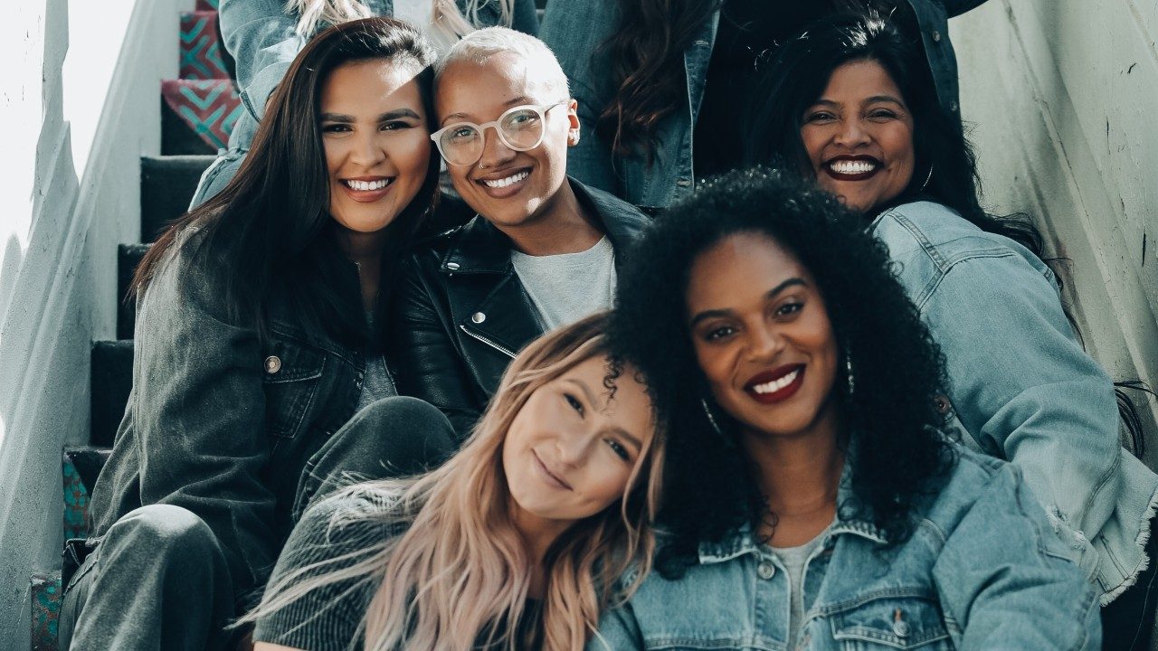 Seven girls in jean jackets sitting on stairs